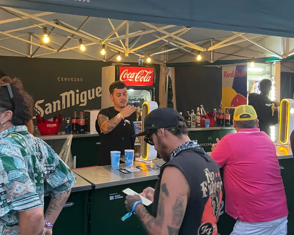 Workout-Kellner serviert am San Miguel Stand beim Musikfestival
