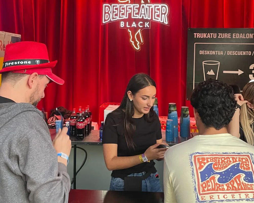 Workout-Kellnerin wird in der Beefeater Bar beim Musikfestival bezahlt