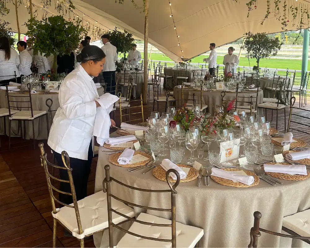 Kellnerin dekoriert Tisch bei Hochzeit