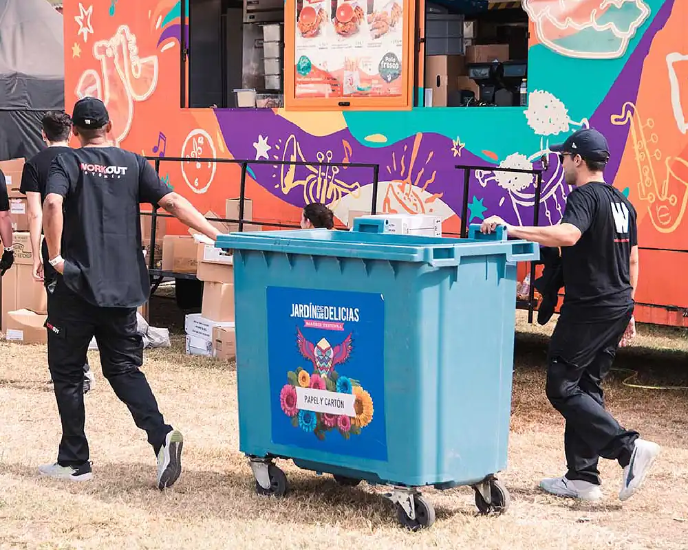 Cleanup personnel pushing garbage dumpster