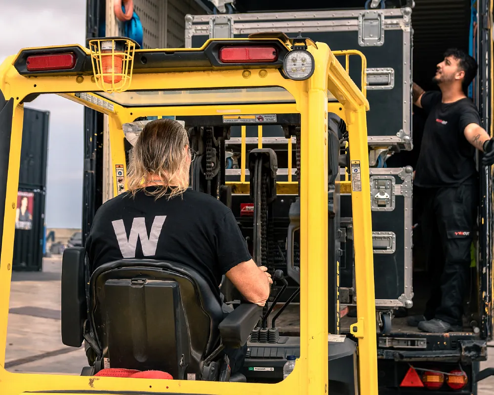 personal montador de conciertos usando carretilla