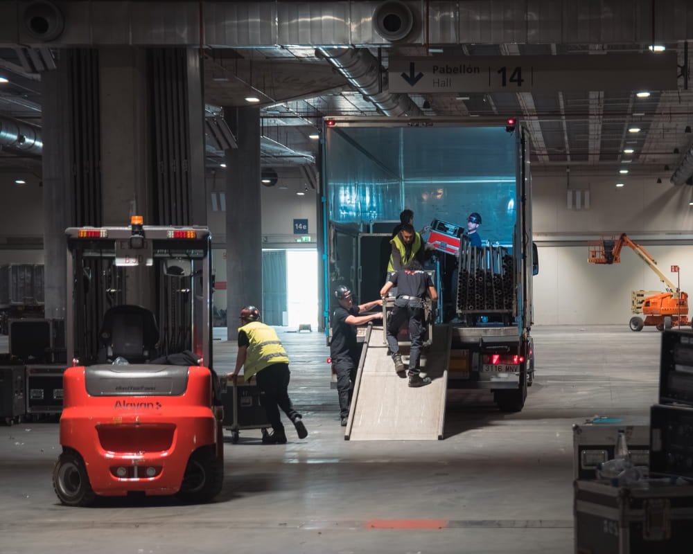 Ein Team von Läufern von Workout Events entlädt technisches Material im Messepavillon.